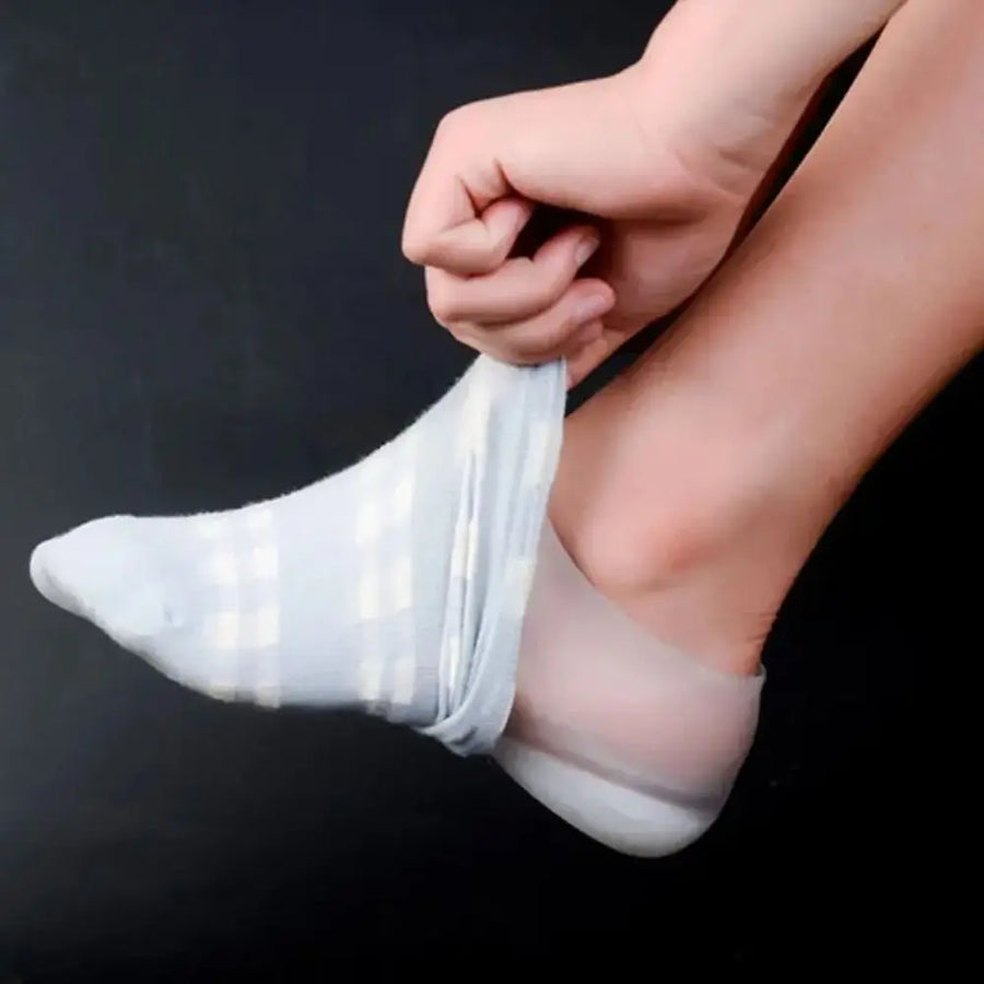Hand pulling a sock over a foot wearing a silicone heel lift