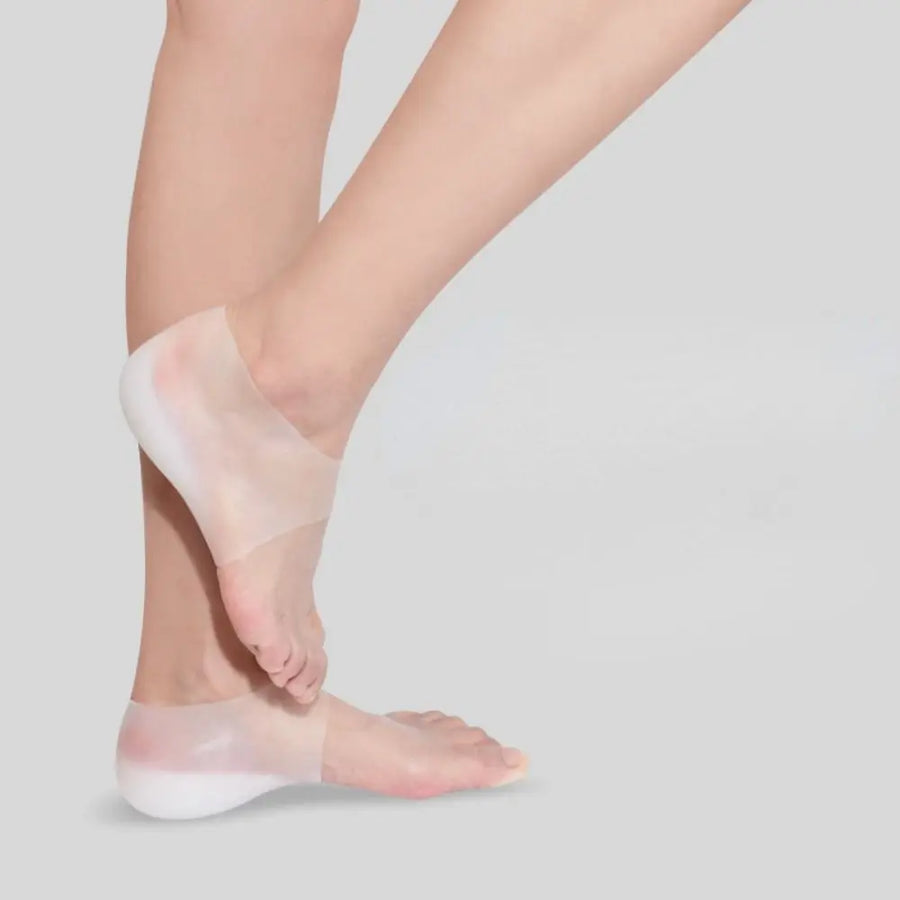 Foot mid-step wearing a clear silicone height insole over the heel