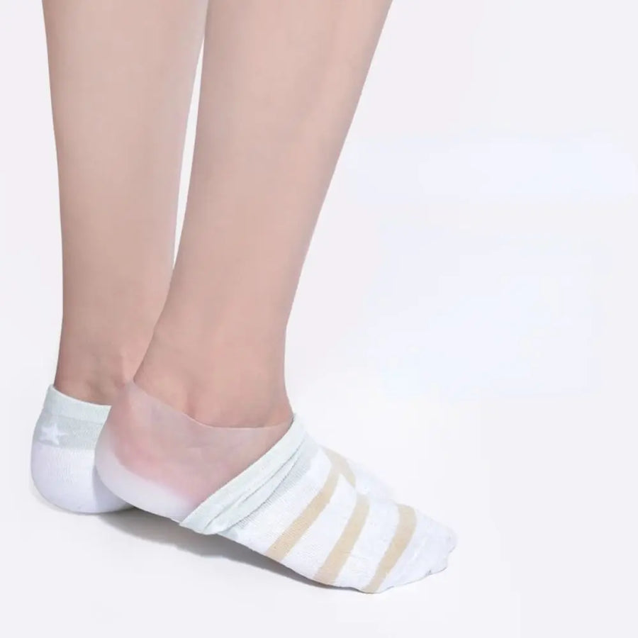 Silicone heel lift worn under a striped ankle sock